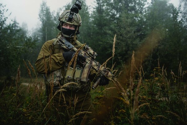 Soldato con un fucile d assalto Kalashnikov nella foresta