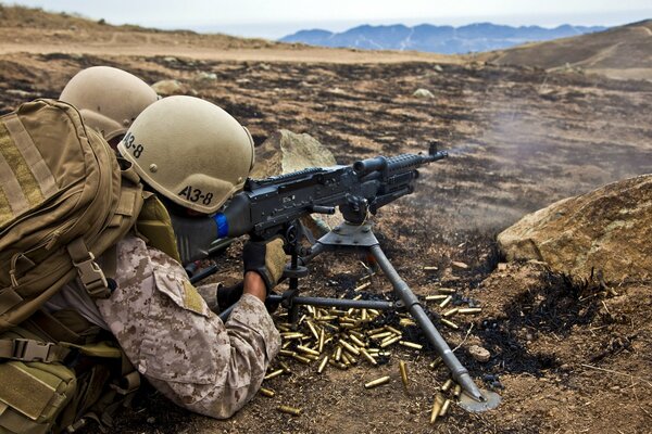 A soldier shoots a rifle on the field