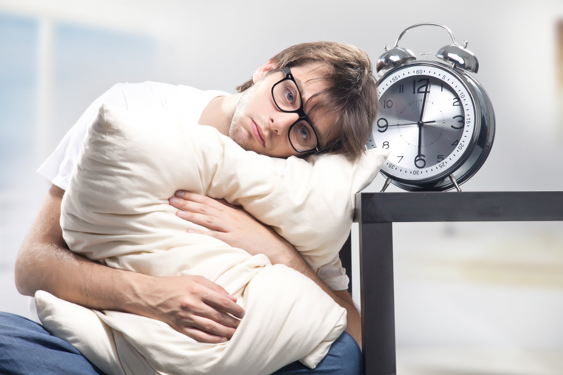 homme lunettes somnolent mécontentement oreiller réveil six heures du matin