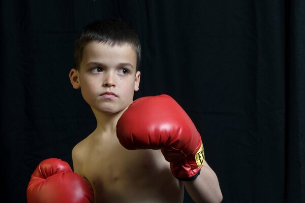 A boy in red boxing gloves