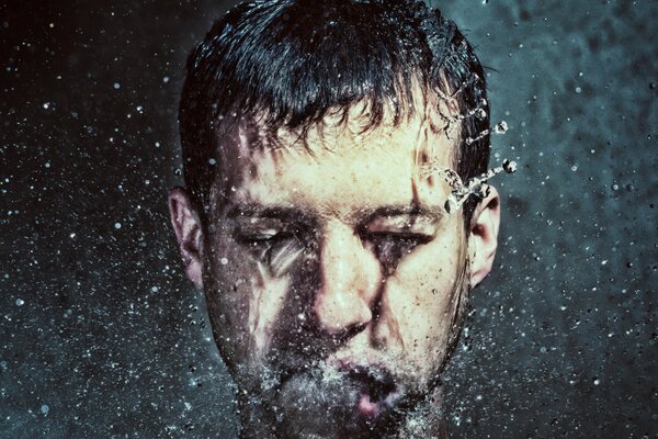 Spruzzi d acqua sul viso di un uomo