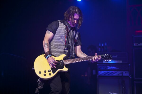 Johnny Depp plays guitar at a concert