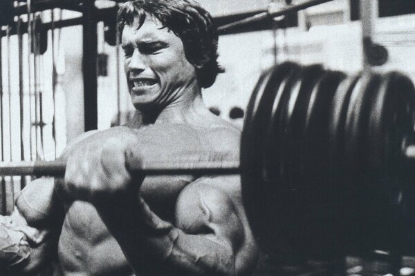 Actor Arnold Schwarzenegger lifts the barbell