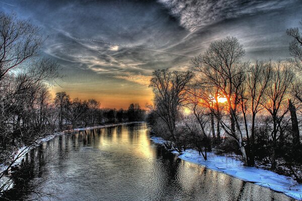 Coucher de soleil d hiver sur fond d arbres, rivière avec neige