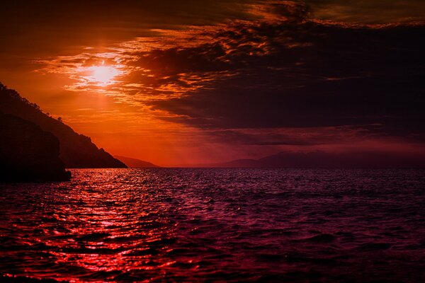 Piękny zachód słońca nad górzystym brzegiem morza