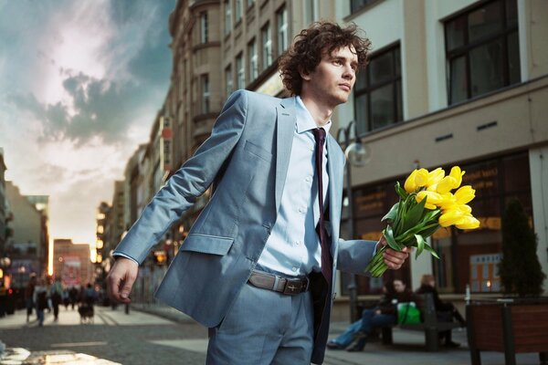 Ein Mann im Anzug mit Blumen in der Hand