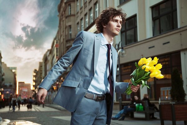 Мужчина в костюме с цветами в руке