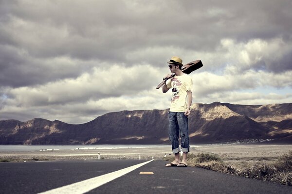 Un hombre con una guitarra en el camino