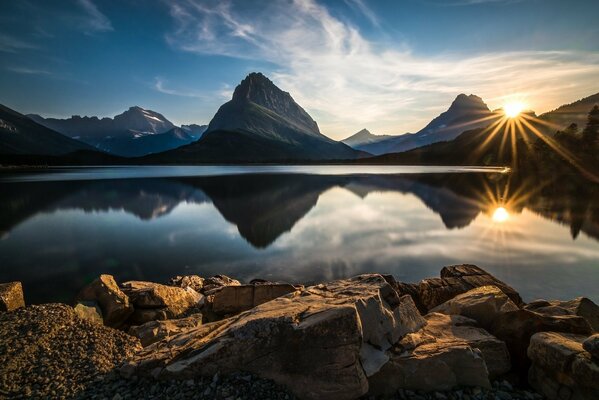 Sonnenuntergang vor dem Hintergrund der Berge und des Sees