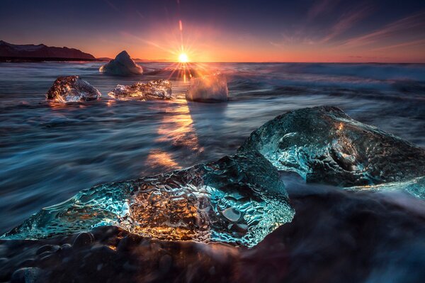 Закат солнца над ледяными скалами в воде