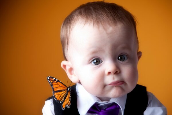 Porträt eines Jungen mit einem Schmetterling auf der Schulter