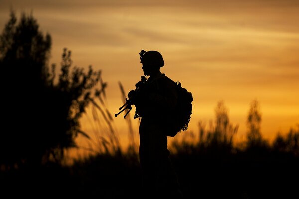 Silueta de un soldado en el fondo de una puesta de sol