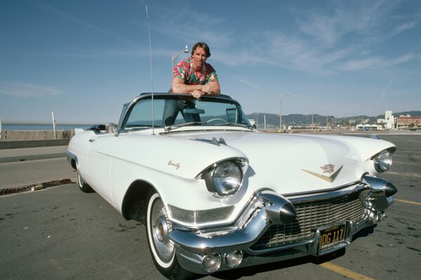 Arnold Schwarzenegger in a vintage Cadillac