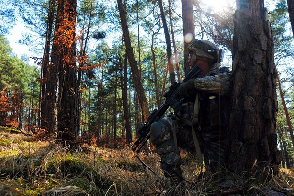 Ein Soldat sitzt in einem Versteck im Wald