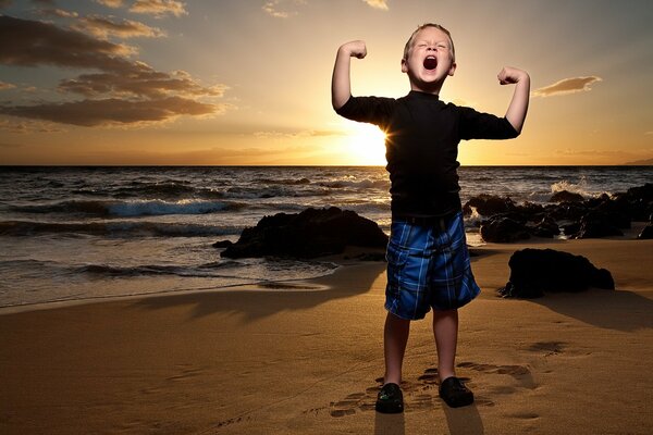 A boy enjoys the sunset on the beach