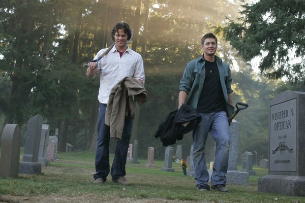 Brothers Sam and Dean at the cemetery with a shovel