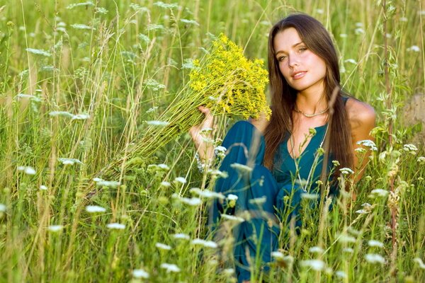 Beautiful girl posing in a field with flowers