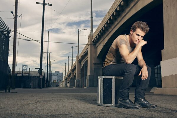 Paul Wesley su una valigia sotto il ponte