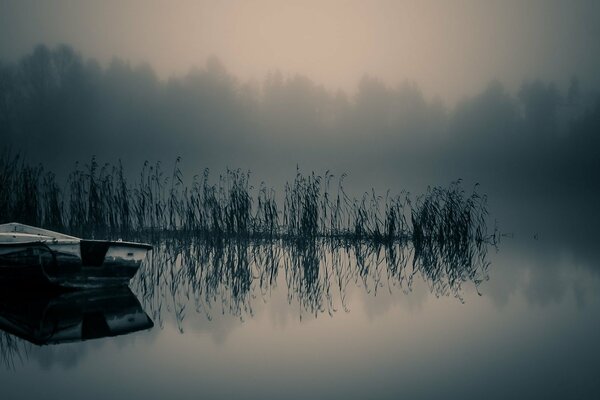 Nebel über dem Fluss. Boot auf dem Wasser