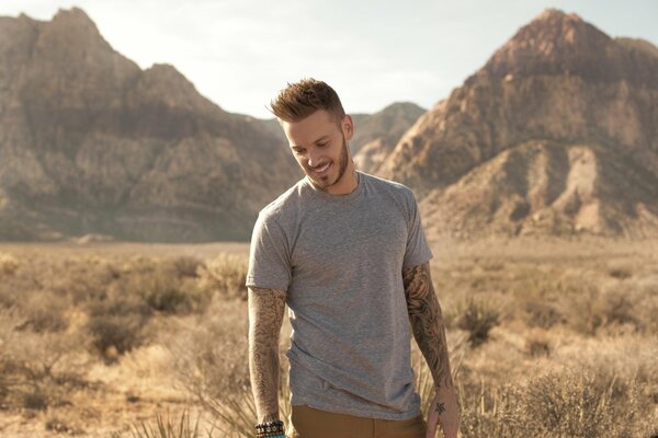 Cantante francese sorridente sullo sfondo delle montagne