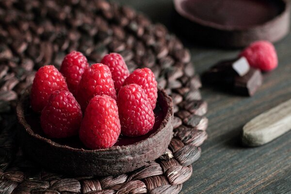 A pie decorated with raspberries on top on the table