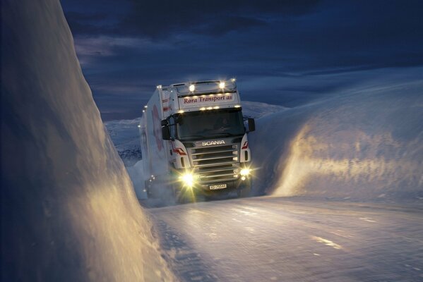 Un camión blanco se abre paso a través del hielo contra el cielo nocturno