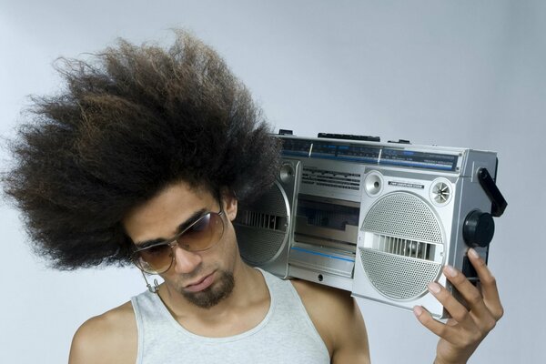 Dude with glasses holds a cassette player