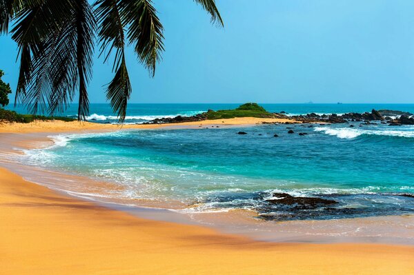 Yellow sandy beach by blue water