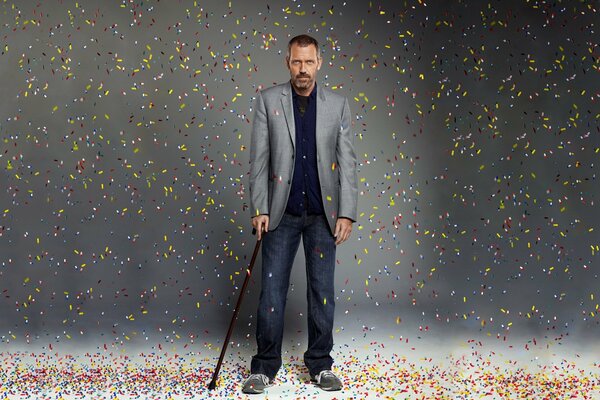 Hugh Laurie steht mit einem Stützstab