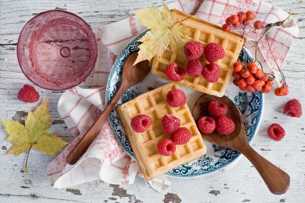 Waffeln mit Himbeeren auf einem blauen Teller