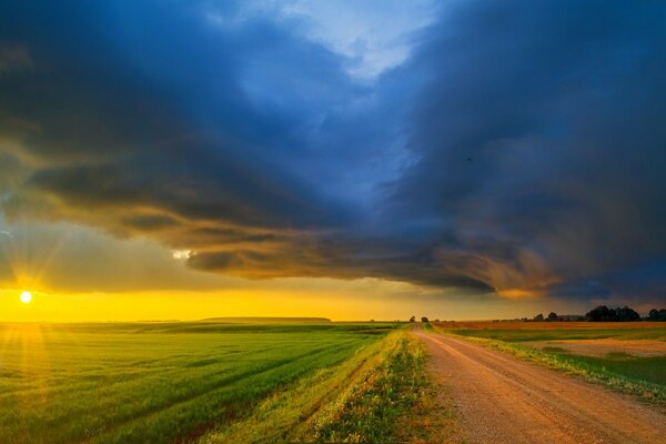 A long road along a green field