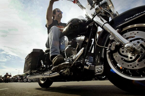 A man rides along the road on a motorcycle