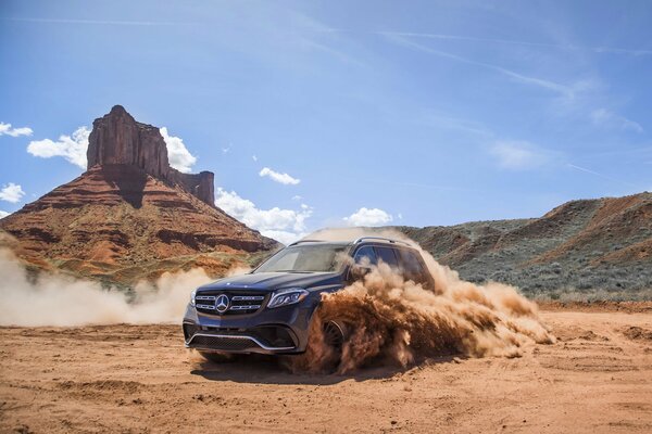 Mercedes entre el polvo de arena en el cañón