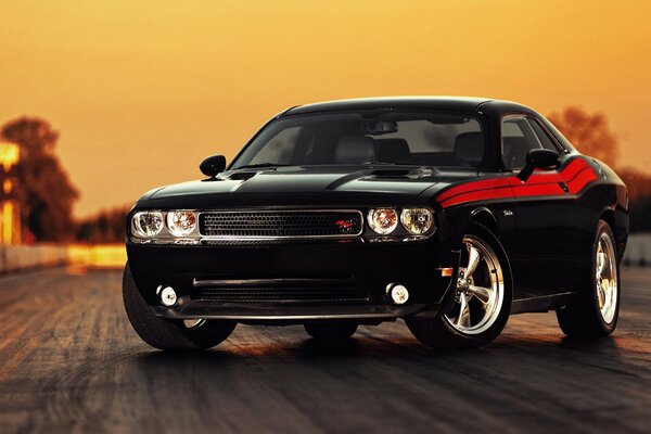 Luxury black car on the background of the evening sky