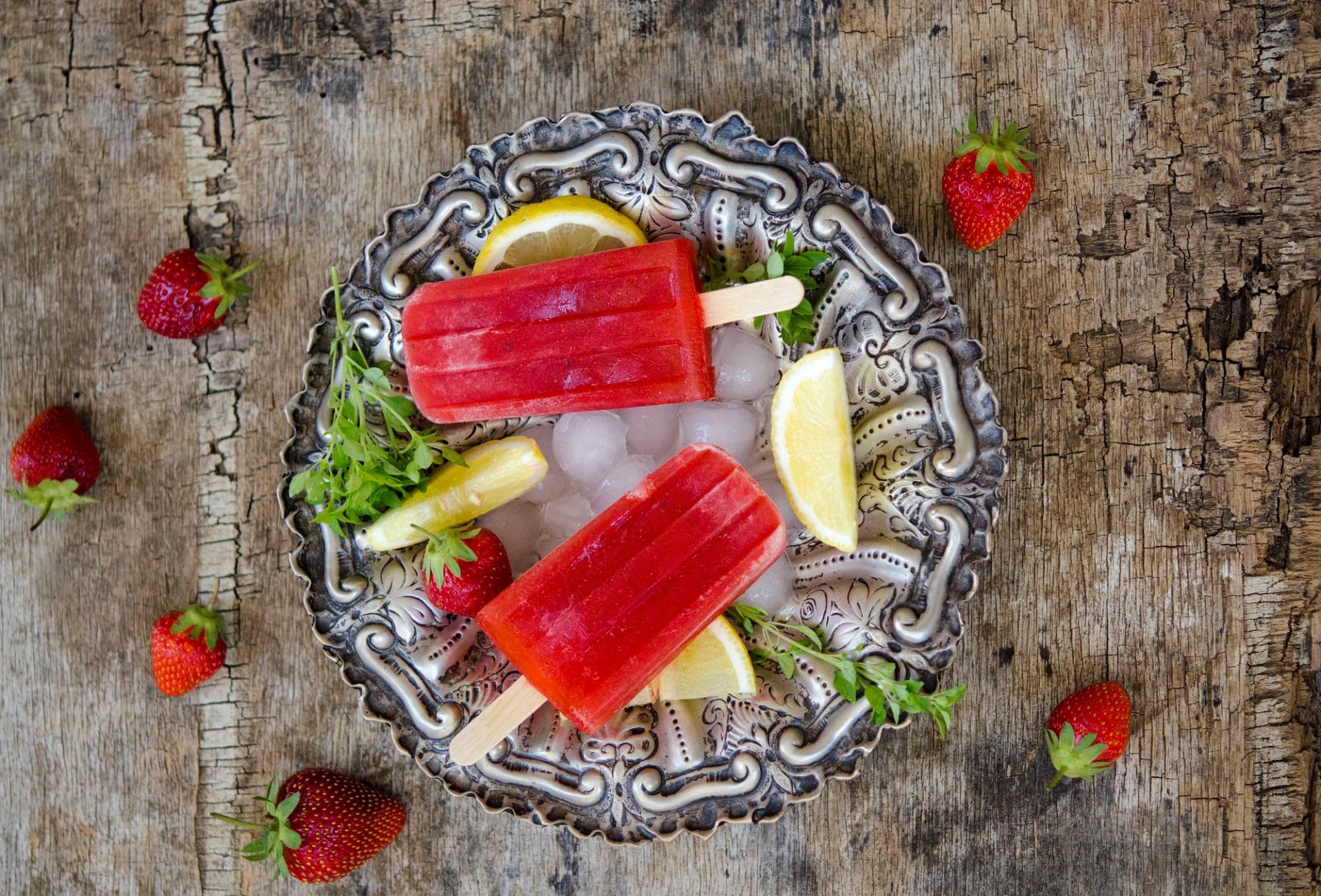 ice cream sticks next lemon strawberry dish table