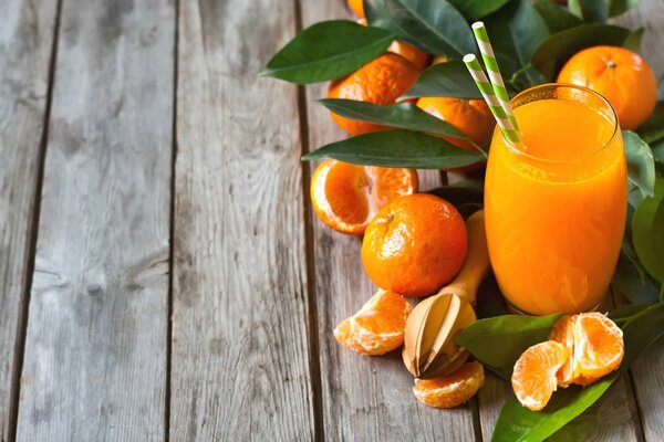 A glass of fresh fruit and tangerines with leaves