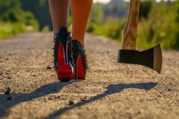 Femme fatale en chaussures et avec une hache