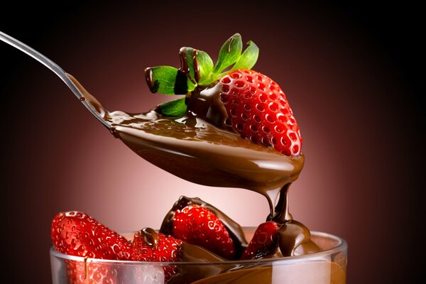 Chocolate-covered strawberries in a glass with a spoon