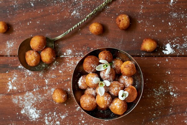 Donuts auf einem Holztisch bestreut mit Puderzucker