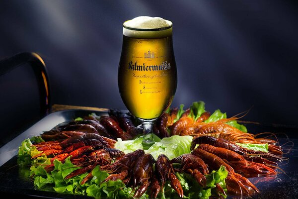 A pile of crayfish with a glass of beer in the middle