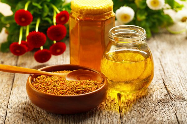 Honey in transparent jars on a background of flowers