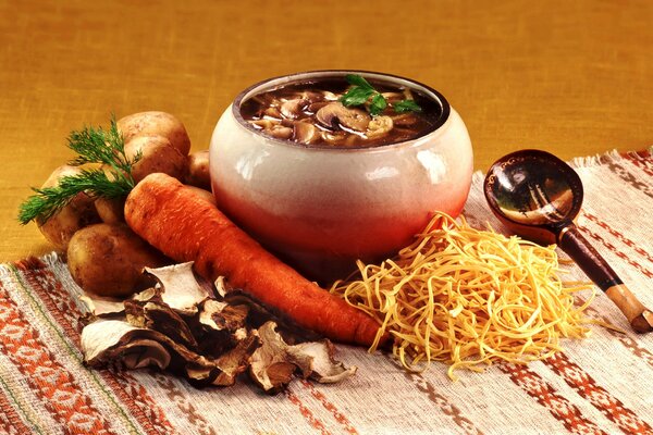 Mushroom soup in a pot with potatoes and carrots