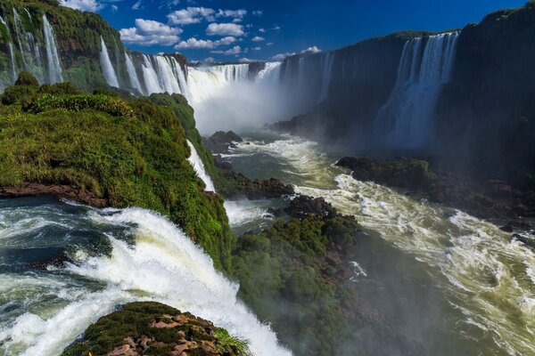 Sullo sfondo del cielo è una cascata tropicale con una nuvola di spruzzi