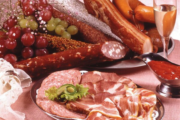 Delicious assortment of meat products decorated with grapes