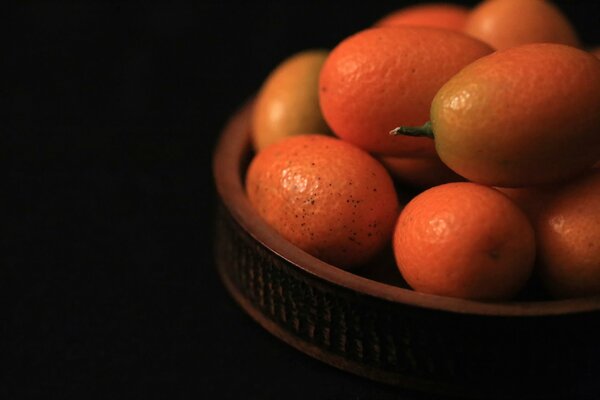 Fruta inusual kumquat en plato de cerámica