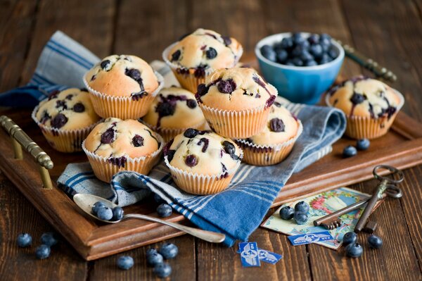 Cupcakes e bacche su un vassoio di legno