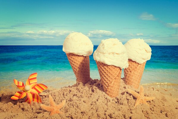 Helado en la arena junto al mar con estrellas de mar