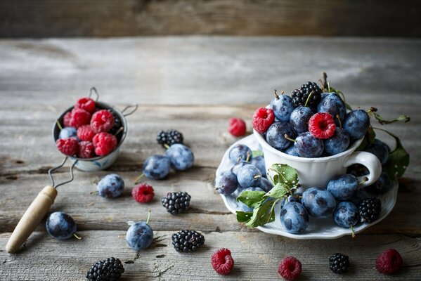 Pflaumen, Himbeeren, Brombeeren auf dem Tisch