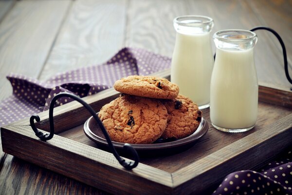 Oatmeal cookies on a tray with milk