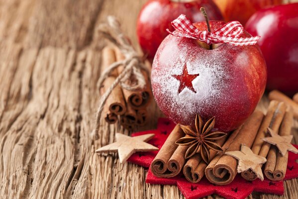 Festliche rote Äpfel mit Schleife und Wintergewürzen